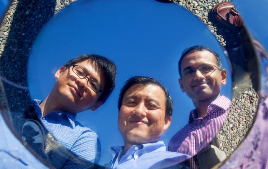 Obraz Shanhui Fana (uprostřed) ze Stanfordu se odráží v prototypu pasivního chladiče; vedle něj stojí jeho kolegové Linxiao Zhu (vlevo) a Aaswath Raman (vpravo). (Foto Norbert von der Groeben, Stanford Engineering)