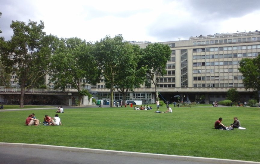 Studenti posedávají na dvoře kampusu. Díky výkonným ostřikovačům se trávník jen zelená (foto: J. Zeman)