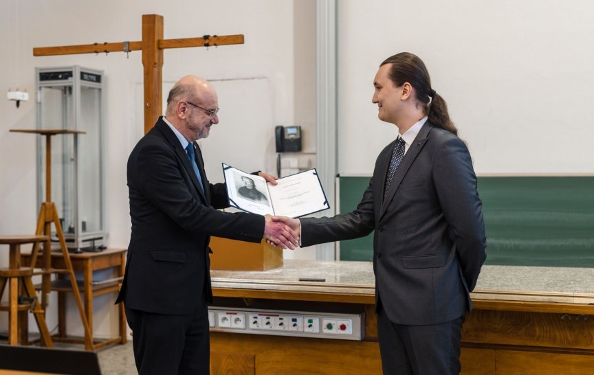 Adam Gindl při přebírání ocenění z rukou děkana MFF&nbsp;UK Mirko Rokyty (foto: Tomáš Rubín)