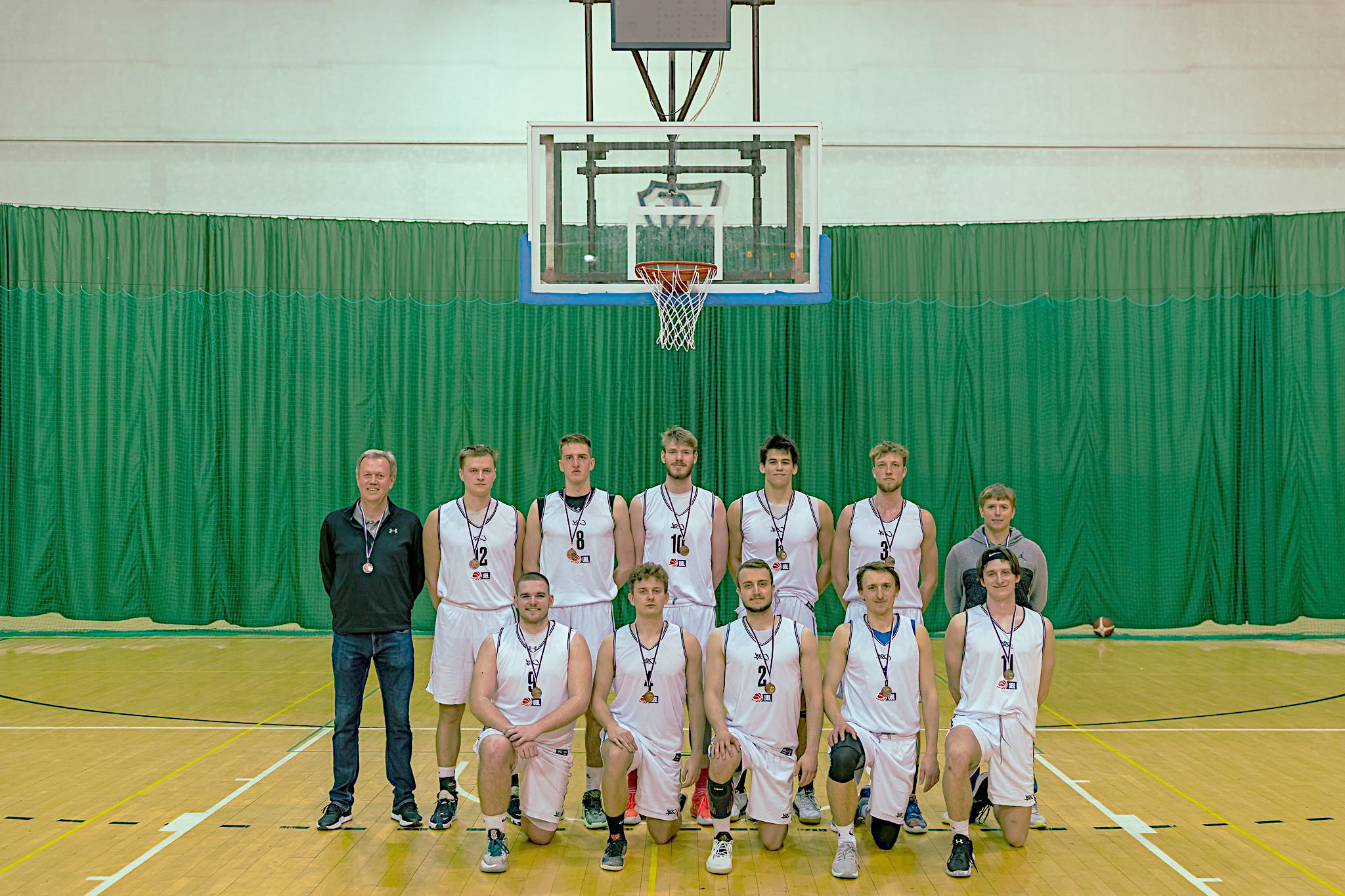 Basketbalový tým UK s trenéry Tomášem Jarošem a Ondřejem Trnkou